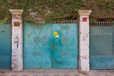 Arka plan üç yeşil eski yıpranmış grunge antika Ferforje kapıları çiçek desenli süsler ve iki beyaz tuğla sütun ile