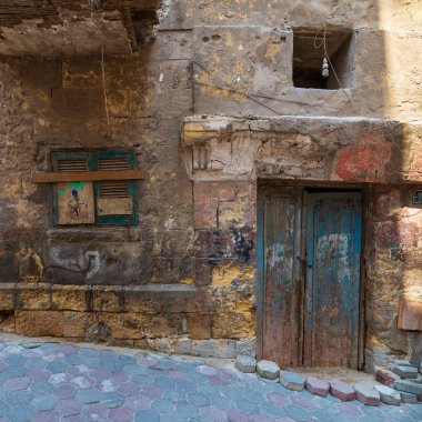 Kırık ahşap kapı ile Grunge taş tuğla duvar ve terk Edilmiş Darb El Labana ilçesinde kırık deklanşör penceresi kapalı, Kahire, Mısır