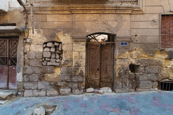 Grunge stone bricks wall with Broken wooden door and closed broken window in abandoned Darb El Labana district, Cairo, Egypt