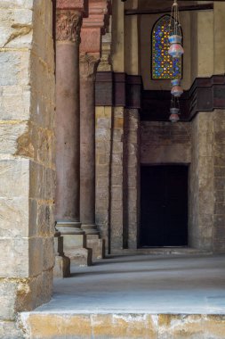 Taş sütunlu Sultan Kadılawun Camii'nde pasaj, renkli vitray pencereler ve ahşap kapı, Kahire, Mısır