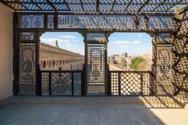 Passage surrounding the Mosque of Ibn Tulun framed by interleaved wooden perforated wall, Mashrabiya, Medieval Cairo, Egypt clipart
