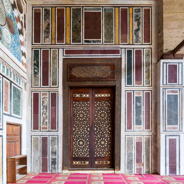 アラベスクの装飾品で飾られた木製のドアを持つ古いカラフルな大理石の壁, カイロ, エジプト — ストック写真