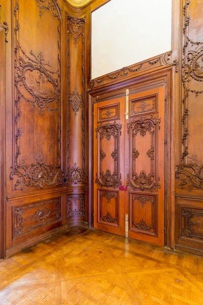 Puerta de madera elegante cerrada con decoraciones grabadas, instalada en arco ornamental de madera —  Fotos de Stock