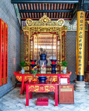 Kuala Lumpur, Malezya - 21 Şubat 2025: Chan She Shu Yuen Atalarının Salonunda sunulan adak ve heykellerin bulunduğu canlı kırmızı ve altın sunak manzarası. Geleneksel Çin kaligrafi ve dekor özellikleri