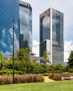 Kuala Lumpur, Malezya - 1 Mart 2025: TRX City Park 'tan Affin Bank ve HSBC Tower, The Exchange TRX. Modern mimari, bulutlu bir gökyüzünün altında yemyeşil kentlerle buluşuyor.
