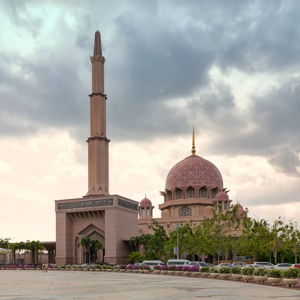 Putrajaya, Malezya - 20 Şubat 2025: İkonik pembe Putra Camii ve onun minaresi bulutlu bir gökyüzü altında. Güzel bir İslami mimari sergileyen önemli bir eser.