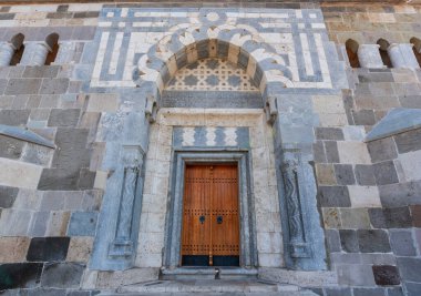 Türkiye 'nin Konya kentindeki Alaeddin Camii' nin süslü girişi, karmaşık taş oymalar, geometrik desenler ve geleneksel ahşap bir kapı sergiliyor. Seljuk mimarisi