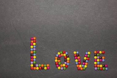 Aşk - taş bir arka plan üzerinde renkli şekerler ile yapılan kelime