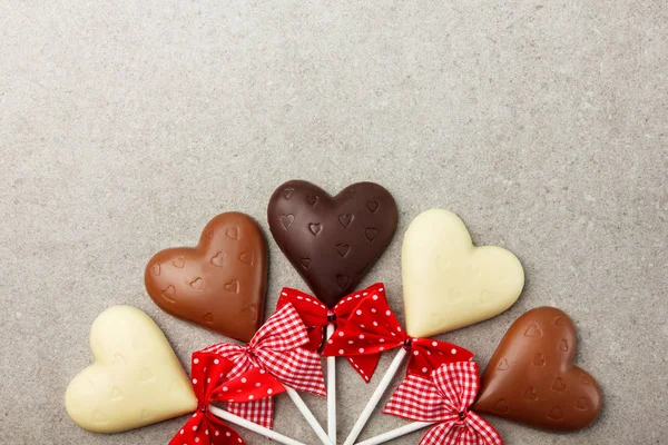 Chocolate hearts with bows. Background with sweets for Valentines Day.