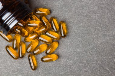 Kapsül Omega 3 ve siyah bir arka plan üzerinde bir kavanoz yakın