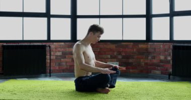 Genç adam genç sağlık güçlendirmek için Yoga oryantal uygulamaları yapmaktadır.