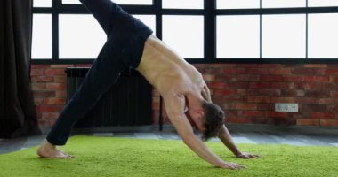 Genç adam genç sağlık güçlendirmek için Yoga oryantal uygulamaları yapmaktadır.
