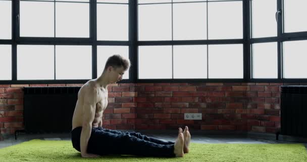 Nuori Mies Harjoittaa Itämaista Joogaa Nuorten Terveyden Vahvistamiseksi — kuvapankkivideo