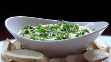 Seramik plaka yakın çekimde yeşillikli humus taze.