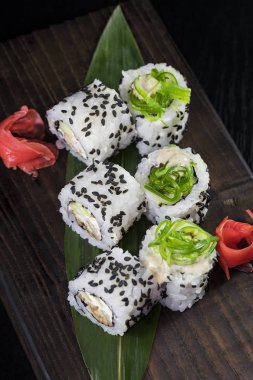 Deniz ürünleri ve balık, sebze, siyah bir arka plan üzerinde Japon geleneksel rulo.