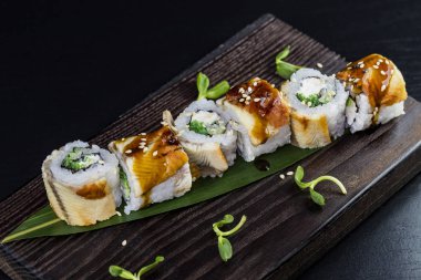 Deniz ürünleri ve balık, sebze, siyah bir arka plan üzerinde Japon geleneksel rulo.