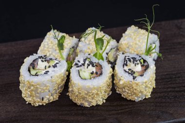 Deniz ürünleri ve balık, sebze, siyah bir arka plan üzerinde Japon geleneksel rulo.