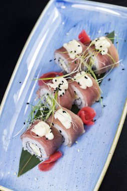 Deniz ürünleri ve balık, sebze, siyah bir arka plan üzerinde Japon geleneksel rulo.