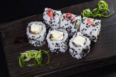 Deniz ürünleri ve balık, sebze, siyah bir arka plan üzerinde Japon geleneksel rulo.