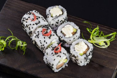 Deniz ürünleri ve balık, sebze, siyah bir arka plan üzerinde Japon geleneksel rulo.