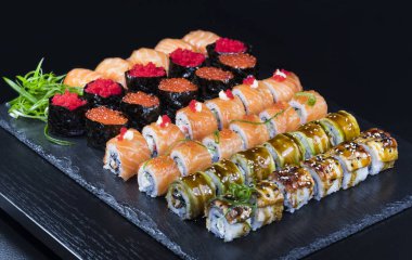 Deniz ürünleri ve balık, sebze, siyah bir arka plan üzerinde Japon geleneksel rulo.