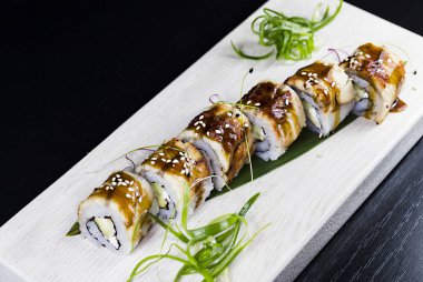 Deniz ürünleri ve balık, sebze, siyah bir arka plan üzerinde Japon geleneksel rulo.