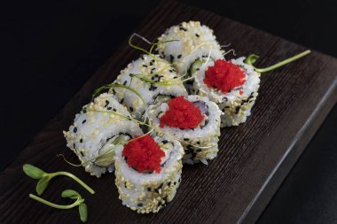 Deniz ürünleri ve balık, sebze, siyah bir arka plan üzerinde Japon geleneksel rulo.