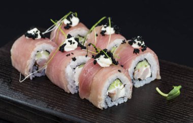 Deniz ürünleri ve balık, sebze, siyah bir arka plan üzerinde Japon geleneksel rulo.