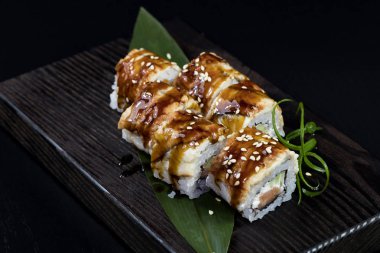 Deniz ürünleri ve balık, sebze, siyah bir arka plan üzerinde Japon geleneksel rulo.