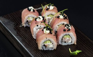 Deniz ürünleri ve balık, sebze, siyah bir arka plan üzerinde Japon geleneksel rulo.