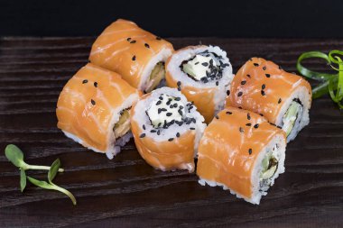 Deniz ürünleri ve balık, sebze, siyah bir arka plan üzerinde Japon geleneksel rulo.