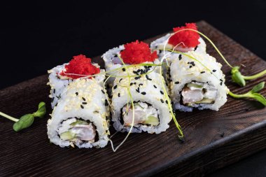 Deniz ürünleri ve balık, sebze, siyah bir arka plan üzerinde Japon geleneksel rulo.