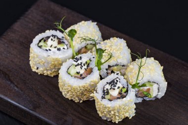 Deniz ürünleri ve balık, sebze, siyah bir arka plan üzerinde Japon geleneksel rulo.