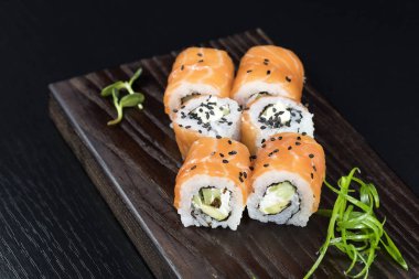 Deniz ürünleri ve balık, sebze, siyah bir arka plan üzerinde Japon geleneksel rulo.