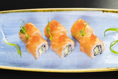 Deniz ürünleri ve balık, sebze, siyah bir arka plan üzerinde Japon geleneksel rulo.