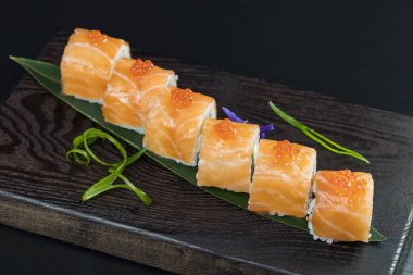 Deniz ürünleri ve balık, sebze, siyah bir arka plan üzerinde Japon geleneksel rulo.