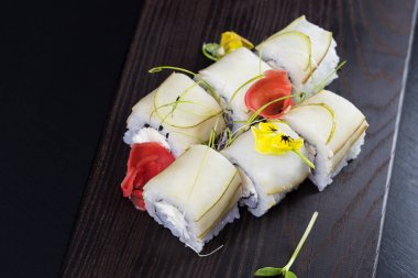 Deniz ürünleri ve balık, sebze, siyah bir arka plan üzerinde Japon geleneksel rulo.