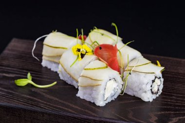 Deniz ürünleri ve balık, sebze, siyah bir arka plan üzerinde Japon geleneksel rulo.