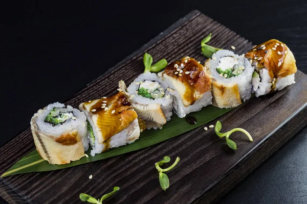 Deniz ürünleri ve balık, sebze, siyah bir arka plan üzerinde Japon geleneksel rulo.