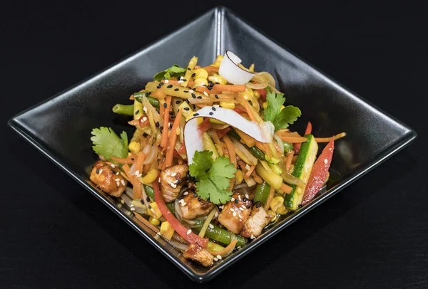 Siyah bir arka planda sebze ve et ile Asya noodle.