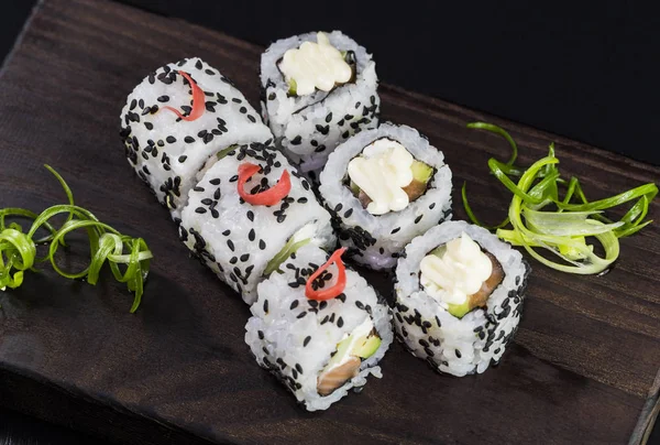 Deniz ürünleri ve balık, sebze, siyah bir arka plan üzerinde Japon geleneksel rulo.