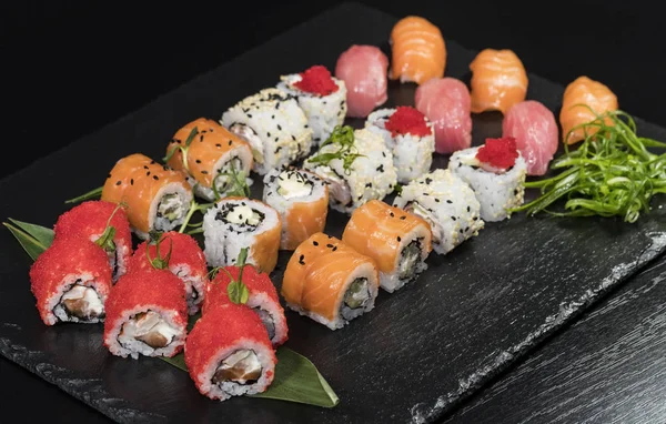 Deniz ürünleri ve balık, sebze, siyah bir arka plan üzerinde Japon geleneksel rulo.