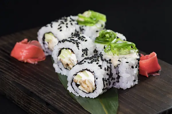 Deniz ürünleri ve balık, sebze, siyah bir arka plan üzerinde Japon geleneksel rulo.