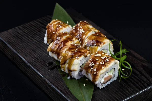 Deniz ürünleri ve balık, sebze, siyah bir arka plan üzerinde Japon geleneksel rulo.