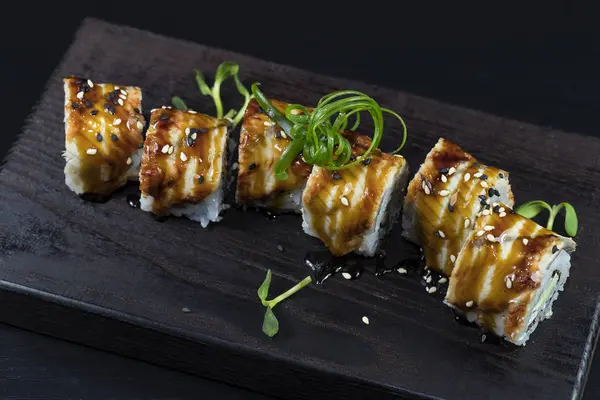 Deniz ürünleri ve balık, sebze, siyah bir arka plan üzerinde Japon geleneksel rulo.