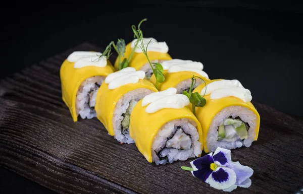 Deniz ürünleri ve balık, sebze, siyah bir arka plan üzerinde Japon geleneksel rulo.