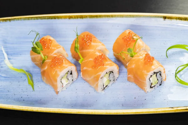 Deniz ürünleri ve balık, sebze, siyah bir arka plan üzerinde Japon geleneksel rulo.