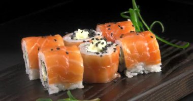 Deniz ürünleri ve balık, sebze, siyah bir arka plan üzerinde Japon geleneksel rulo.