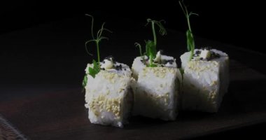 Deniz ürünleri ve balık, sebze, siyah bir arka plan üzerinde Japon geleneksel rulo.