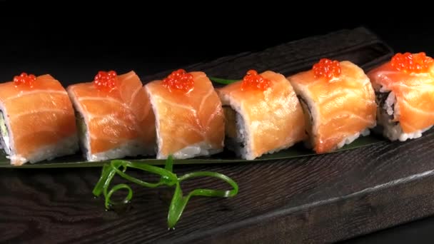 Japanse Traditionele Broodjes Met Zeevruchten Vis Groenten Een Zwarte Achtergrond — Stockvideo